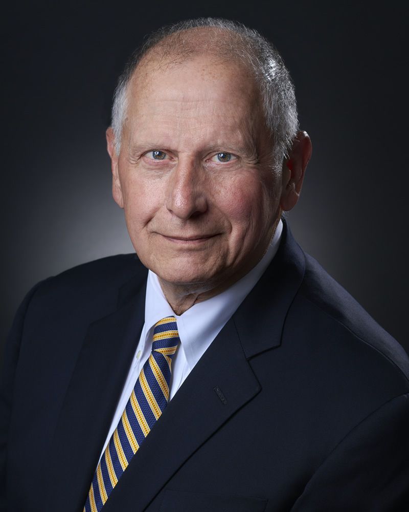 A man in a suit and tie is smiling for the camera