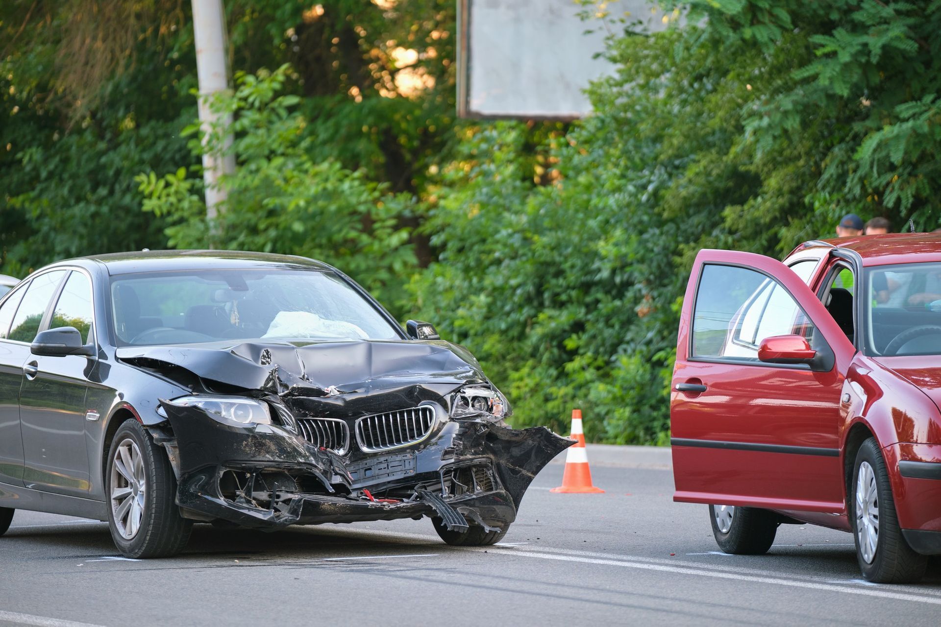 A black car and a red car are involved in a car accident.