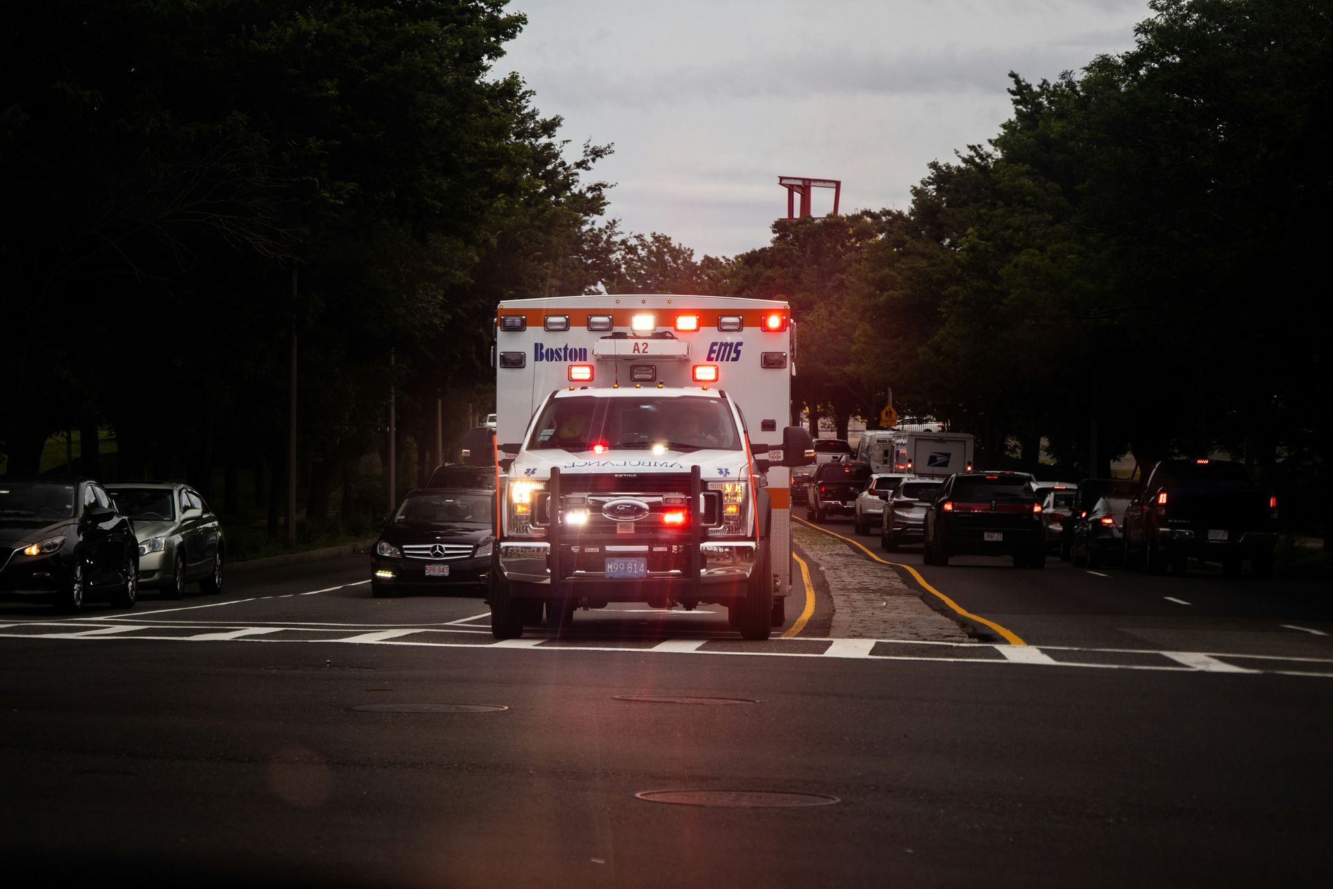 An ambulance is driving down a street at night